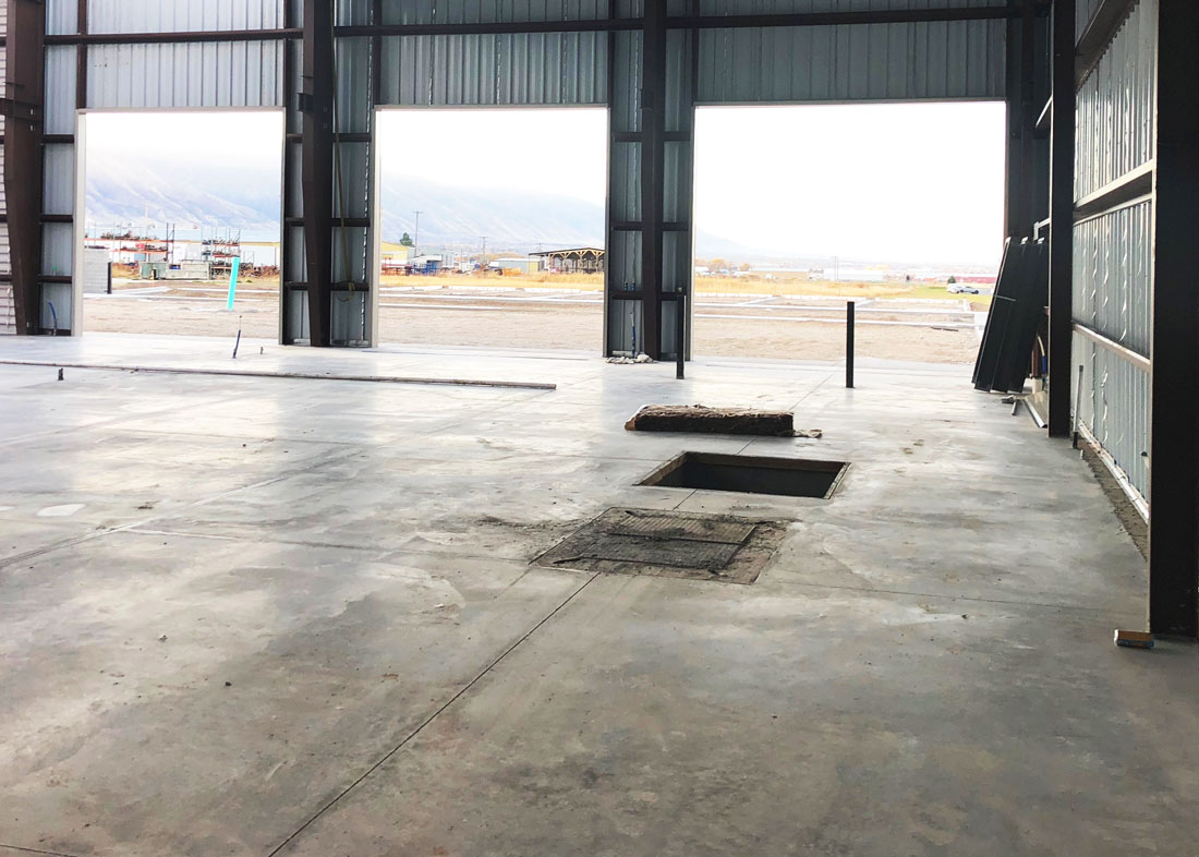 a concrete floor with three large garage doors
