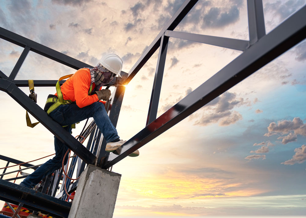 a man welding at a steel building construction site