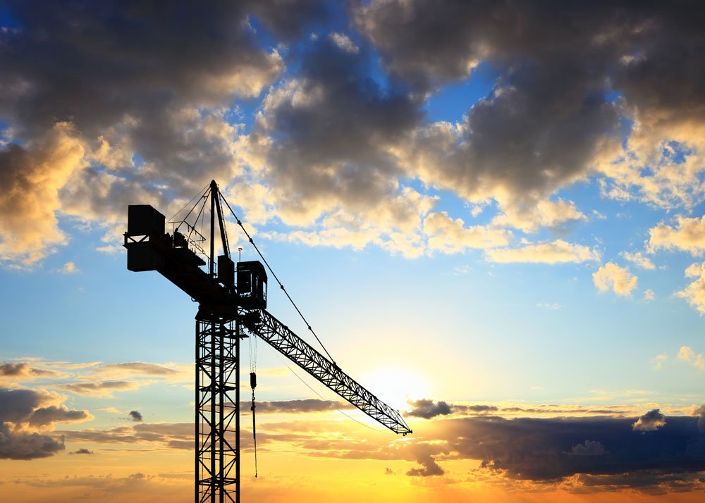 a crane at construction site at sunset