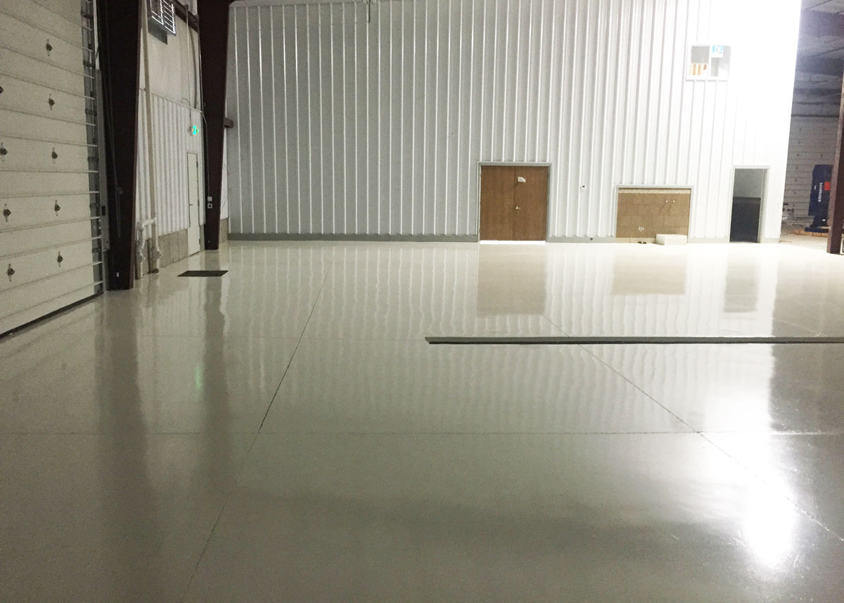 a white polished concrete floor with a garage door