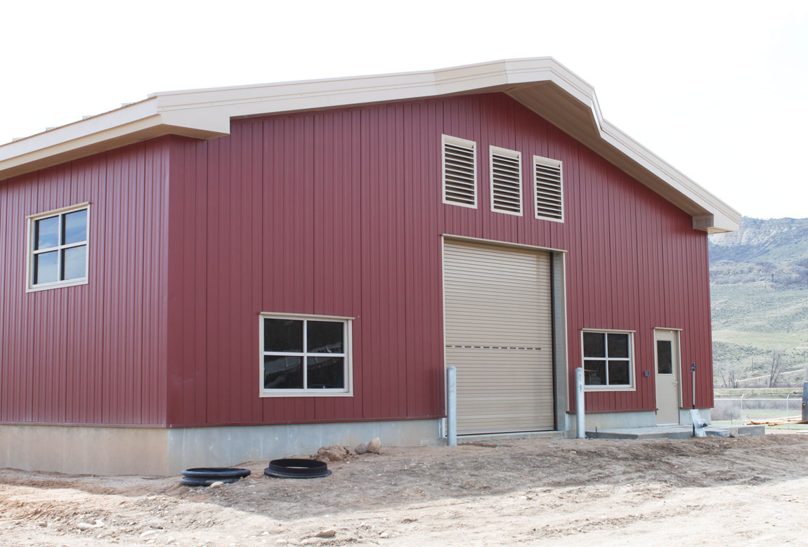 a red agricultural shed with windows