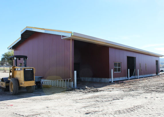 a large agricultural shed with a yellow tractor