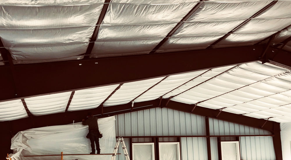 installing the insulation at a steel building construction site